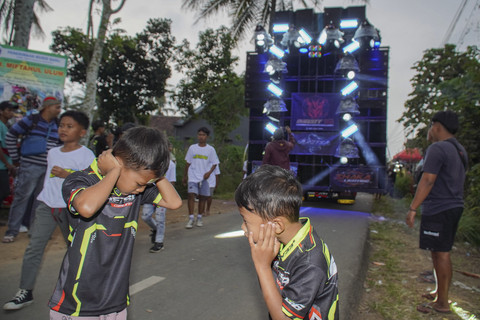 Warga menyaksikan gelaran Urek Urek Carnival yang diiringi perangkat audio berkapasitas besar di Desa Urek-urek Kecamatan Gondanglegi, Kabupaten Malang, Jawa Timur, Sabtu (12/7/2025). Foto: Irfan Sumanjaya/ANTARA FOTO