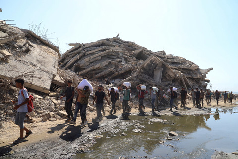 Warga Palestina membawa pasokan bantuan yang masuk ke Gaza melalui Israel, Jalur Gaza utara, Jumat (1/8/2025). Foto: Ebrahim Hajjaj/REUTERS