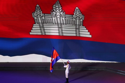Petugas membawa bendera Kamboja tanpa diikuti atlet saat acara penutupan SEA Games 2021 Vietnam di Vietnam Asian Indoor Games Stadium, Hanoi, Vietnam, Senin (23/5/2022). Foto: Chalinee Thirasupa/REUTERS
